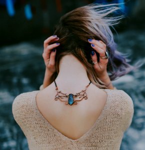 Woman Wears Gold-colored Blue Gemstone Pendant Necklace photo