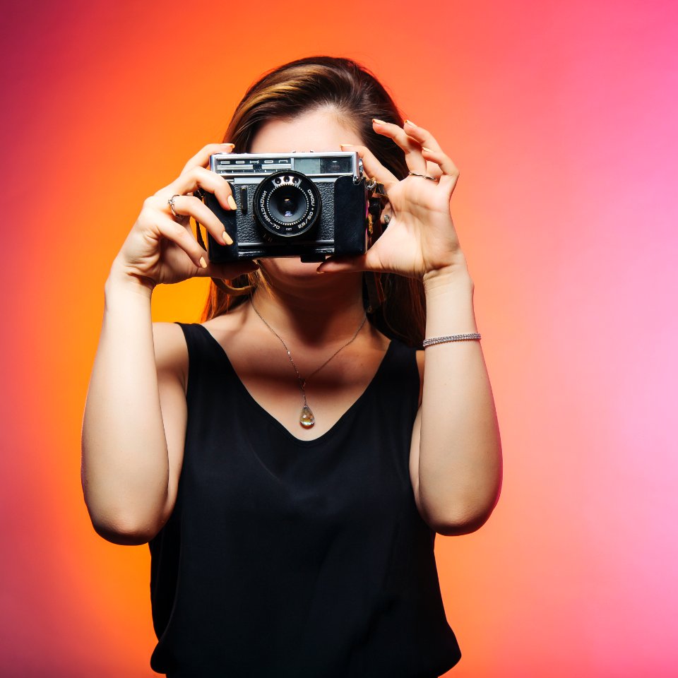 Woman Wearing Black Sleeveless Top Holding Gray Camera