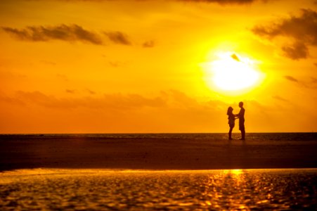 Man And Woman Standing Near Seashore Under Sunset photo