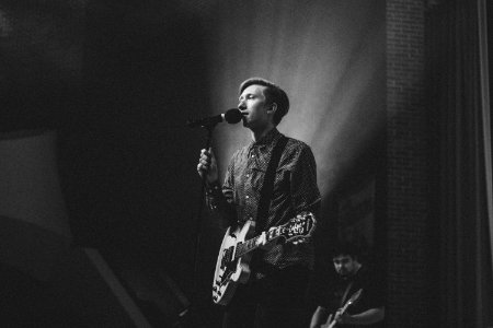 Grayscale Photography Of Person Near On Pedestal Microphone