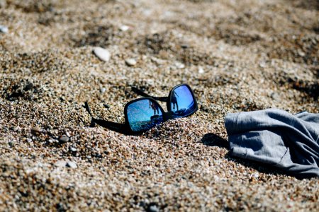 Close-Up Photography Of Sunglasses On Sand photo
