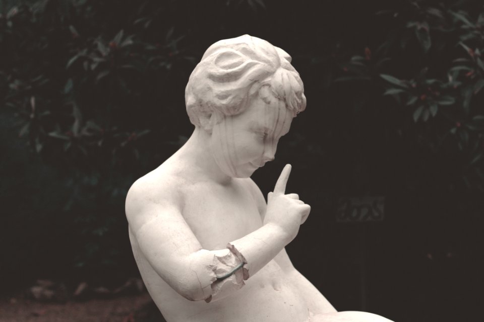 Close-up Photography Of Boy Statue