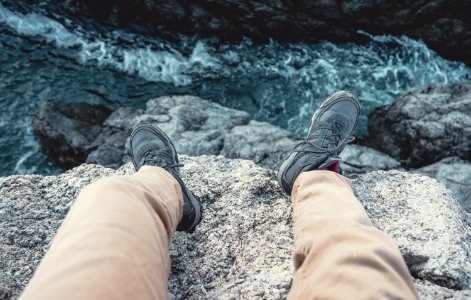 Photo Of Man Sitting On The Cliff photo