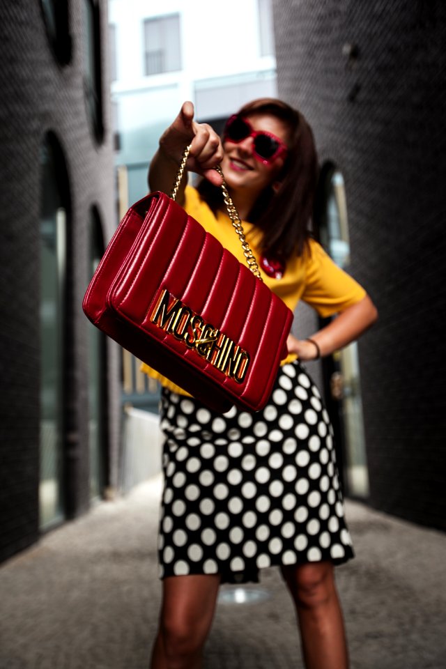 Woman Wearing Yellow Crew-neck T-shirt While Holding Red Handbag