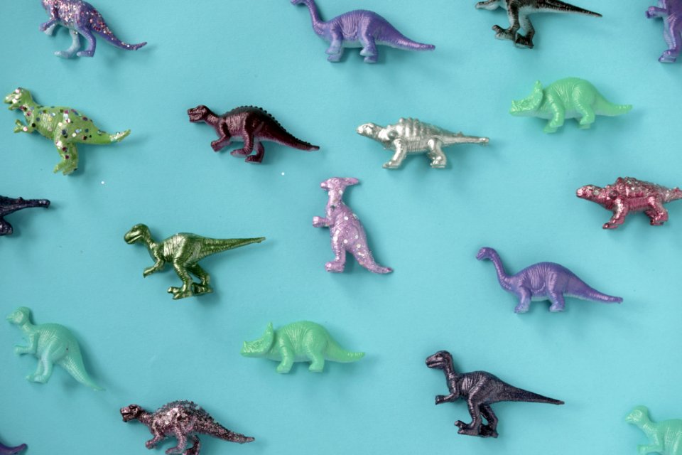 Assorted-color Plastic Dinosaur Figurine Lot On Teal Surface photo