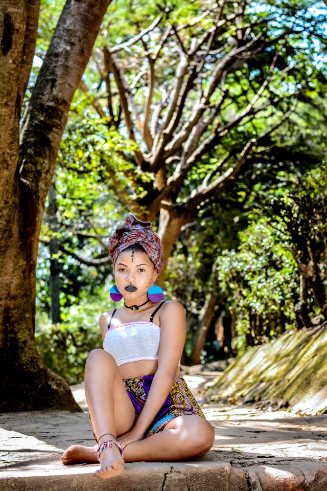 Woman Wearing White Crop Top Sitting On Concrete Floor Near Tree