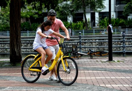 Photography Of Girl Riding Bike Beside Man photo