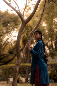 Woman Wearing Blue And Red Dress Standing Beside Tree photo