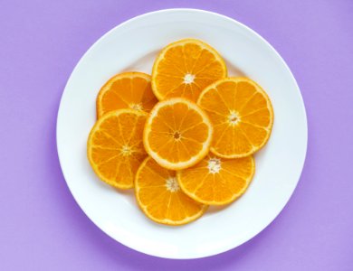 Sliced Orange Fruits On Round White Ceramic Plate photo