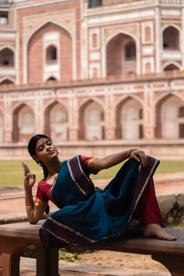 Woman In Blue Red And Purple Saree Dress Lying On Bench