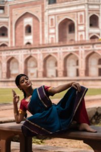 Woman In Blue Red And Purple Saree Dress Lying On Bench photo