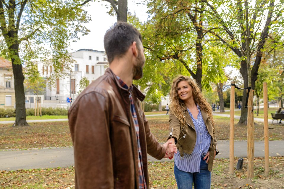 Man Holding Womans Hand Near Trees photo