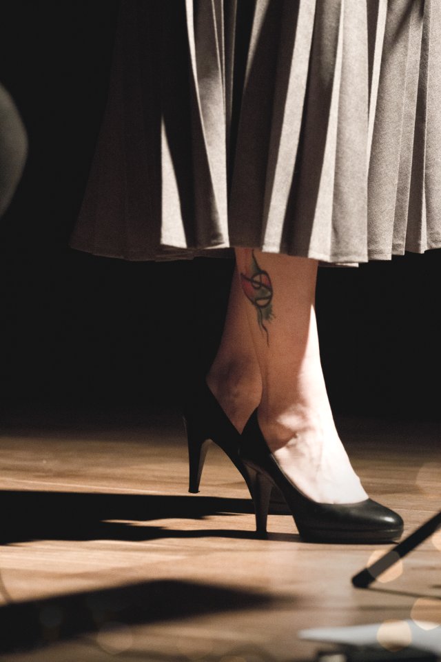 Woman In Black Heeled Shoes Standing On Brown Surface