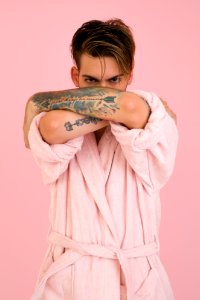 Man Wearing White Bathrobe Stands Near Pink Wall photo