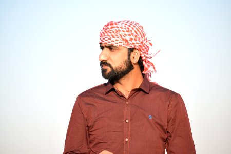Portrait Photo Of Man In Red Button-up Shirt And Red-and-white Headscarf photo