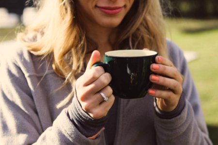 Woman Wearing Gray Zip-up Jacket Holding Ceramic Cup