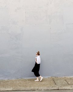 Woman Wearing Black Maxi Dress And Pair Of White Flats Standing Beside Gray Wall photo