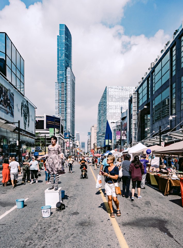 People In The Middle Of The Street Under Blue Cloudy Skies