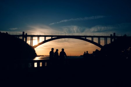 Silhouette Of People Standing Near The Bridge photo