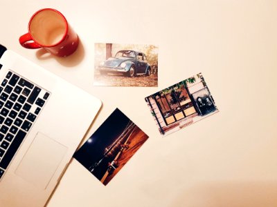 Three Assorted Photos On Desk Beside Laptop And Mug photo