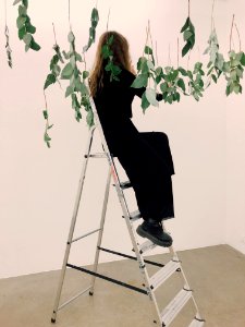 Woman Sitting On Tip Of Ladder