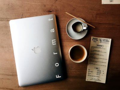 Photo Of Macbook Near Cup And Saucer photo