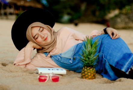 Woman In Blue Denim Dungaree Lying On Sand photo