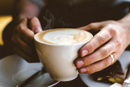 Close-Up Photo Of Person Holding Cup Of Coffee photo
