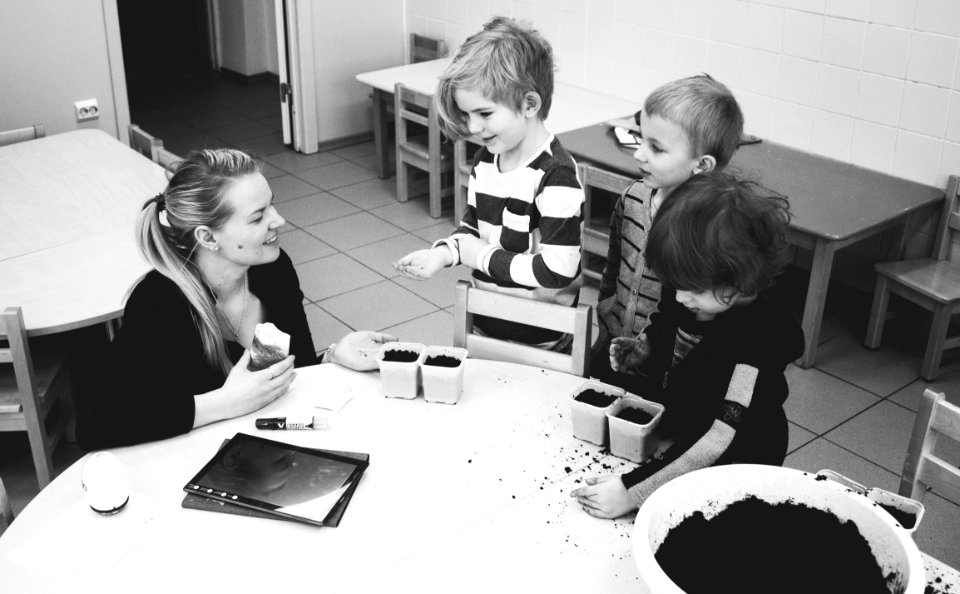 Mother And Three Child Near Table With Mud