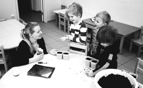 Mother And Three Child Near Table With Mud