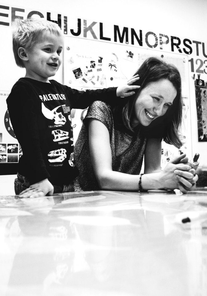 Grayscale Photography Of Woman Smiling Near Kid In Black Sweater