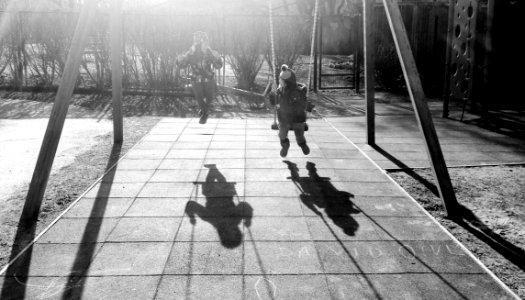 Monochrome Photography Of Children On Swing photo