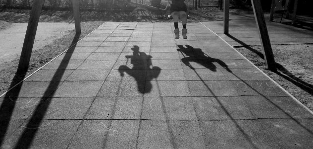 Grayscale Photo Of Two Children Using Swing