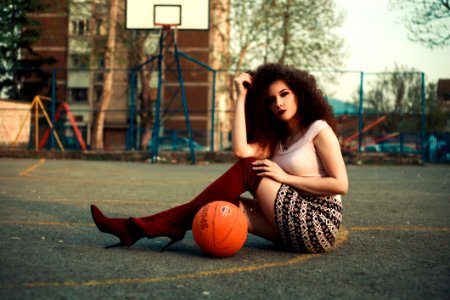 Photo Of Woman Sitting On Basketball Court Beside Ball photo