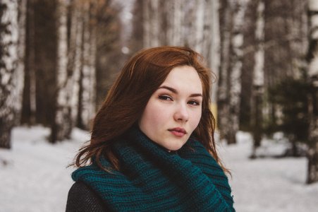 Selective Focus Photography Of Woman Wearing Blue Scarf While Standing On Snow Covered Forest photo