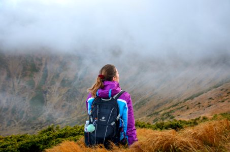 Woman Standing On Mountain Wearing Black Backpack photo