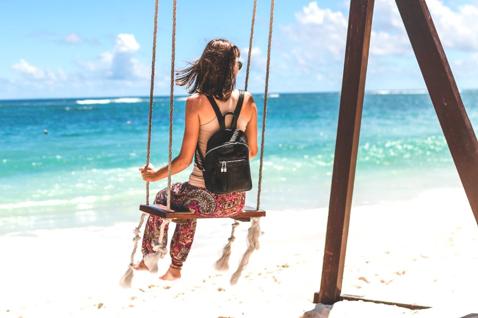 Woman Sitting On Seashore Swing