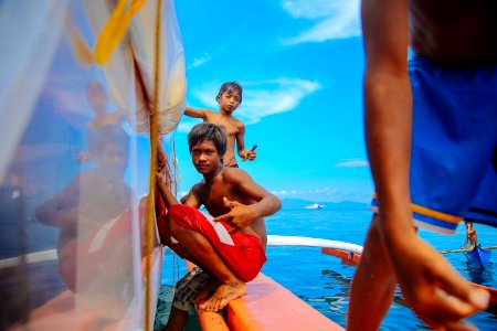 Teenage Boys Sitting On Edge Of Boat