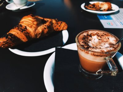 Clear Glass Cup Filled With Cappuccino Beside Croissant Bread photo