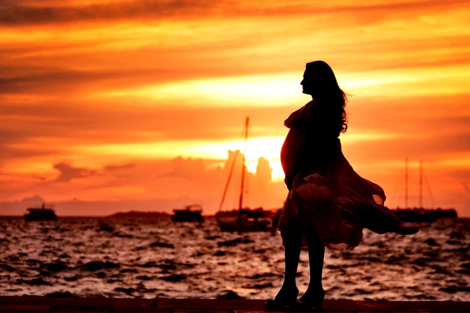 Pregnant Woman Standing Near Seashore During Sunset