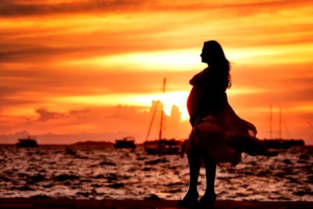 Pregnant Woman Standing Near Seashore During Sunset photo