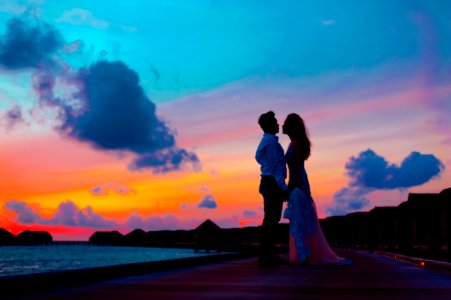 Man And Woman Wearing Wedding Attire Standing On Sea Dock During Golden Hour