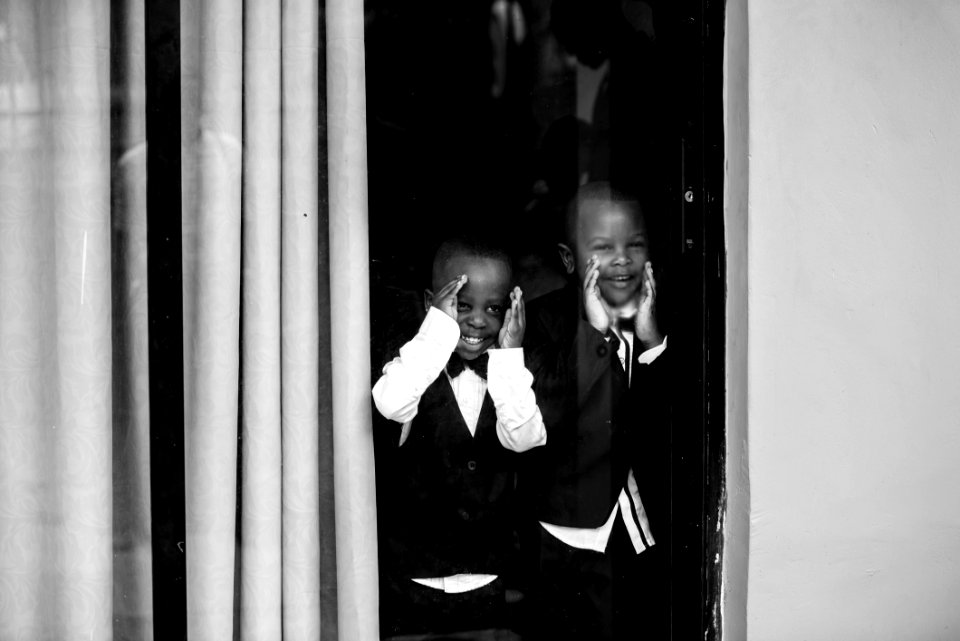 Two Boys In Front Of Glass Window