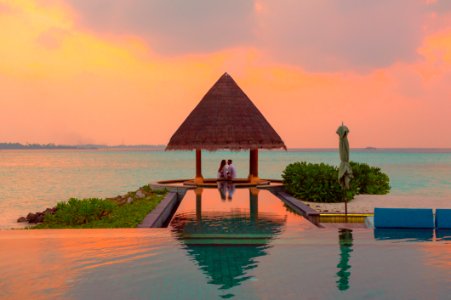 Couple Under Hut Beside Sea And Infinity Pool photo