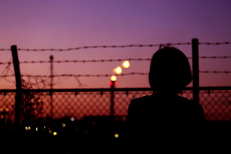 Silhouette Of Person In Front Of Fence photo