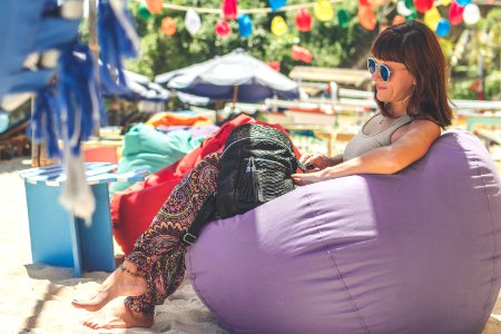 Woman Wearing Gray Tank Top Sitting On Purple Bean Bag