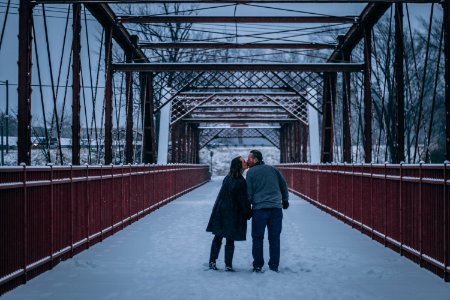 Couple Kissing On Bridge Covered With Snow photo