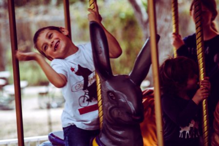 Boy In White T-shirt Riding Carousel