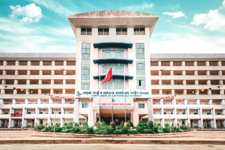 White Concrete Building With Red Flag Outside photo