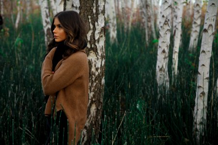 Woman Wearing Brown Sweater Standing On Woods Surrounded By Grass photo